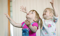 little-girls-catching-soap-bubbles-room