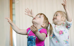 little-girls-catching-soap-bubbles-room