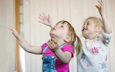 little-girls-catching-soap-bubbles-room